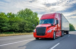 An image of a tractor trailer truck driving down the road